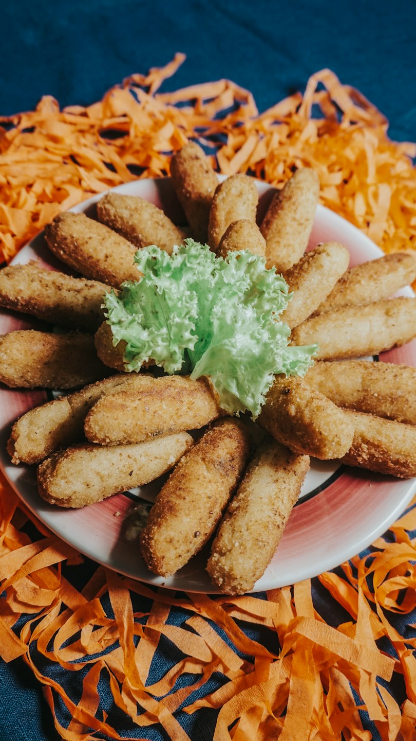 Golden fried croquettes arranged around lettuce on a plate.