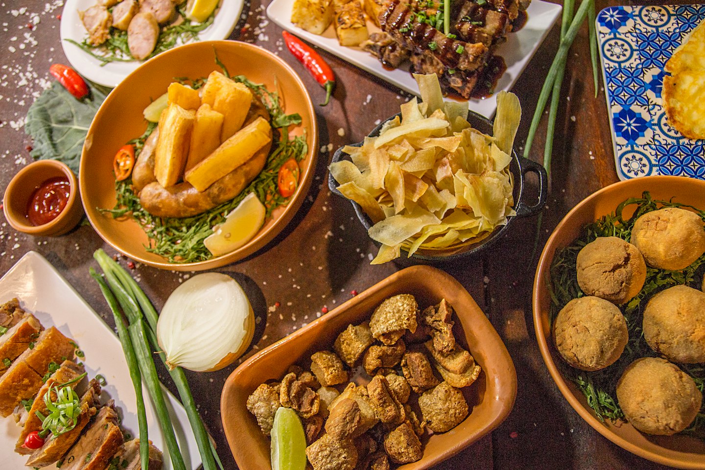 A variety of traditional Brazilian appetizers arranged on a wooden table.