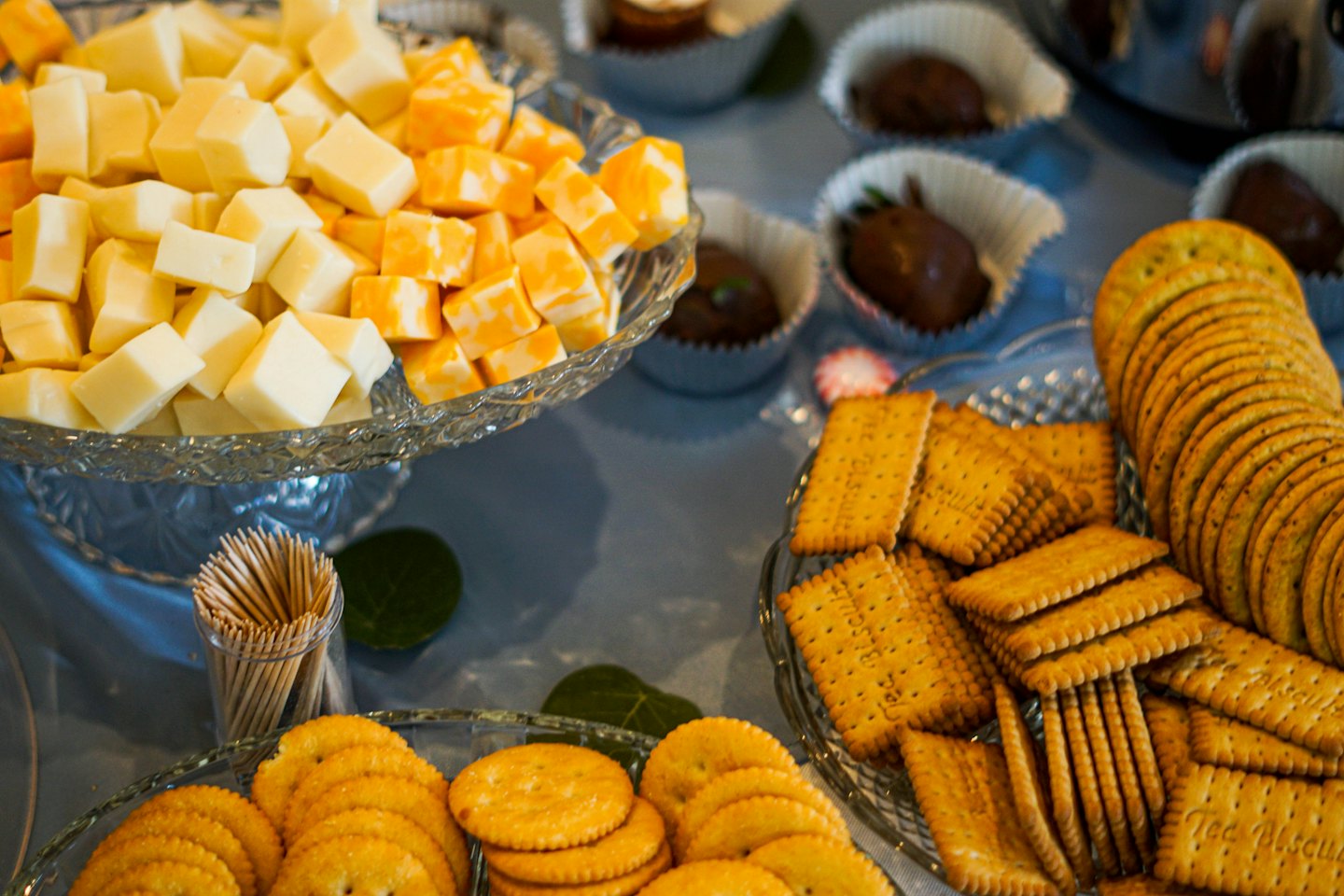 Cheese and crackers arranged on a blue tablecloth.