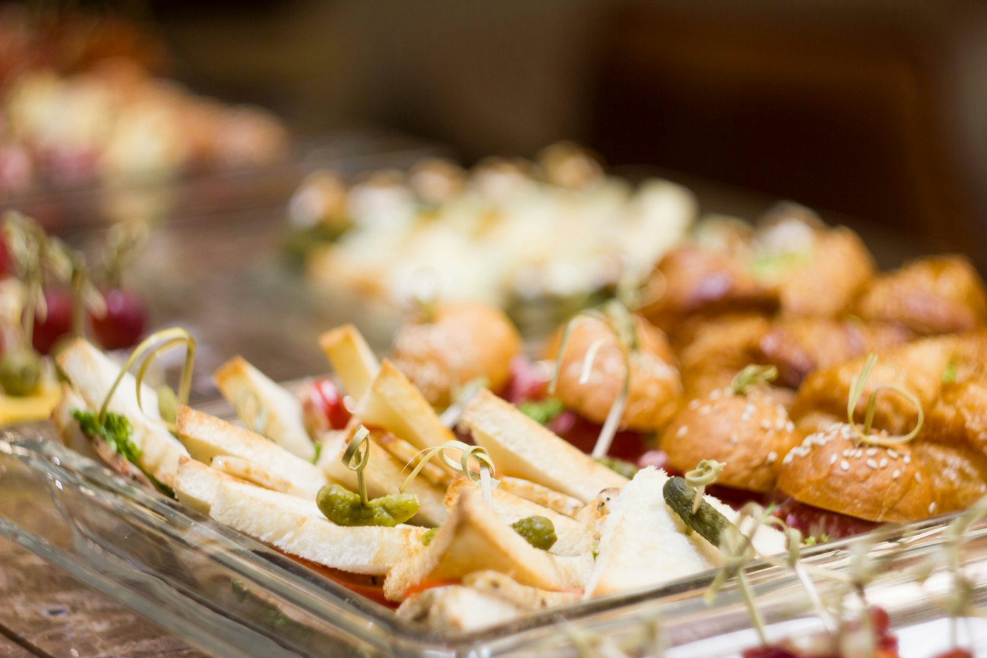Mini sandwiches and sliders on glass platters.